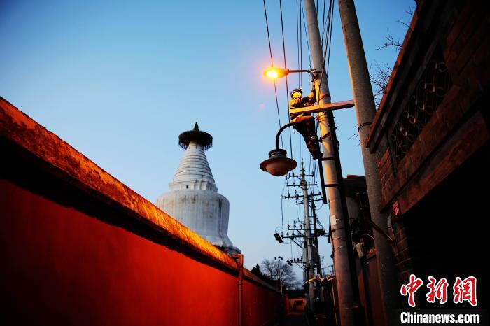 元旦前夕，北京城市照明管理中心員工檢修維護白塔寺等地區(qū)照明設施。　張超 攝