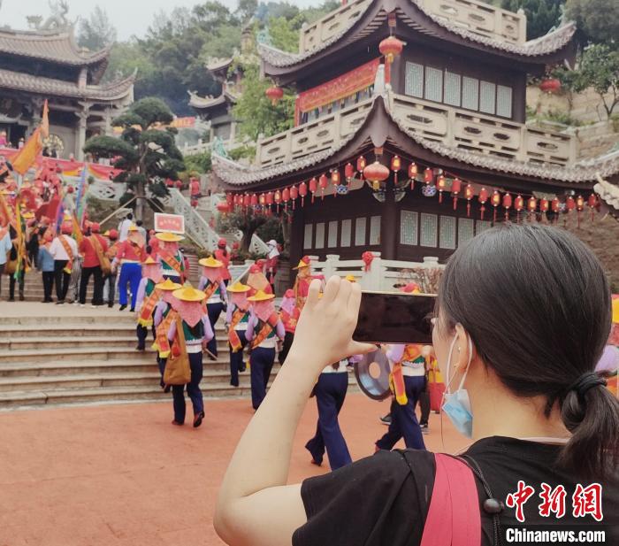 獨(dú)具民族特色的進(jìn)香人潮吸引游客駐足拍照?！「邅喅?攝