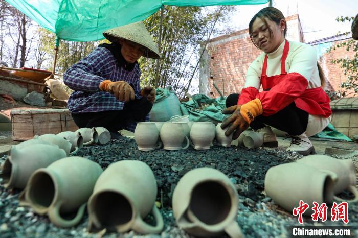 3月4日，廖亮清(左)和愛人吳龍梅擺放待燒制的“威寧砂陶”器具?！■暮陚?攝