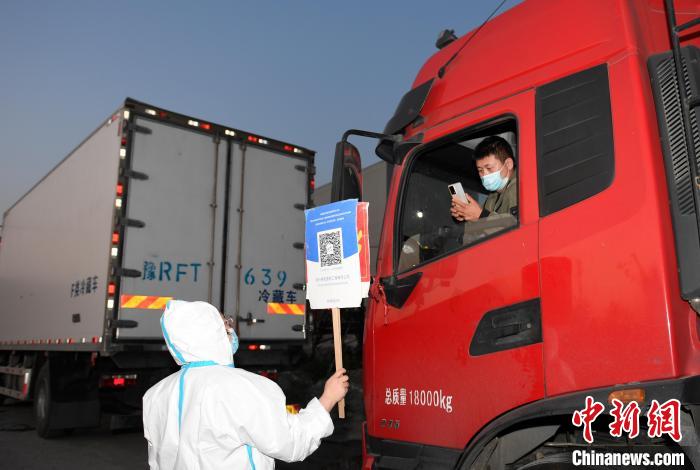 工作人員舉牌讓貨車司機(jī)掃碼?！⊥鮿?攝