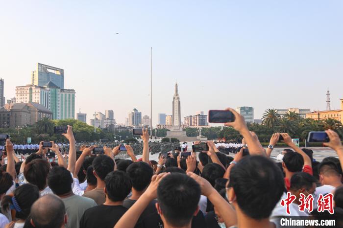 圖為不少市民在八一廣場(chǎng)上觀看升旗儀式。　劉力鑫　攝