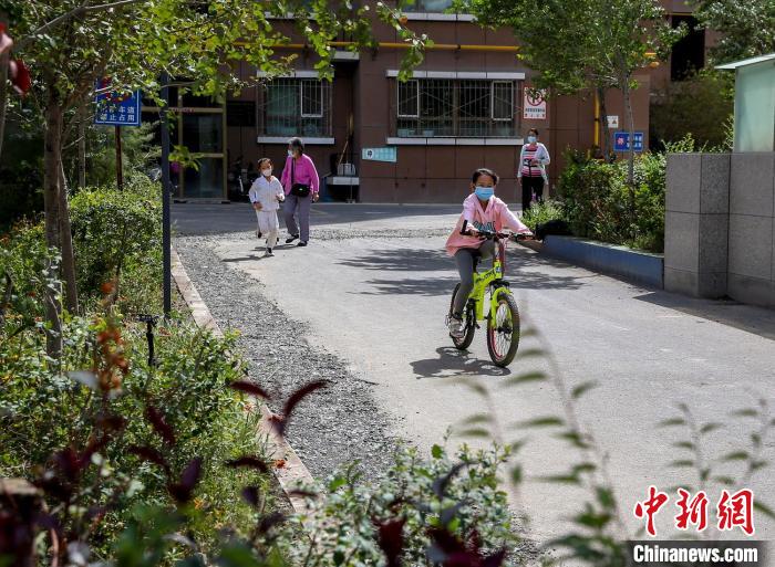 烏魯木齊市水磨溝區(qū)七道灣東街南社區(qū)，居民下樓在小區(qū)內(nèi)活動?！＄娦?攝