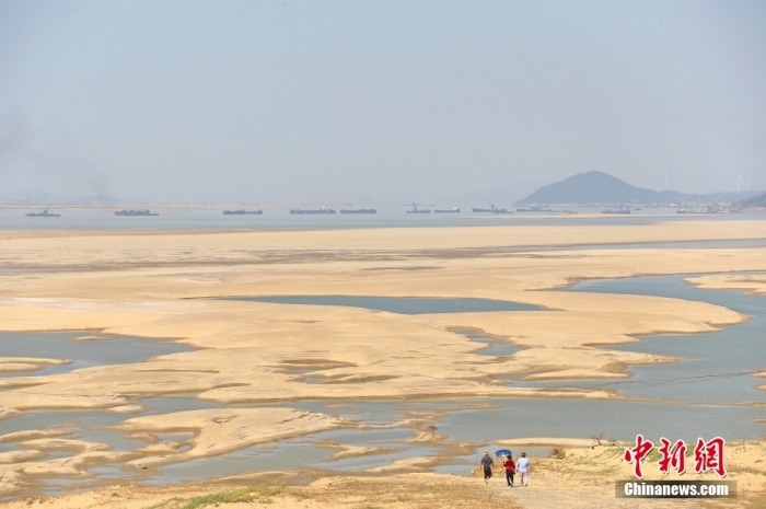 資料圖：在江西省九江市都昌縣鄱陽湖水域，湖床大面積裸露，幾名游客走向干涸的鄱陽湖湖床。 <a target='_blank' href='/'>中新社</a>記者 劉占昆 攝