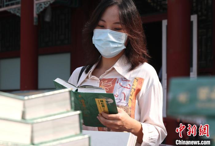 圖為一名游客翻閱《頤和園日歷·2023(草木賁華)》?！?lt;a target='_blank' href='/'>中新社</a> 易海菲 攝