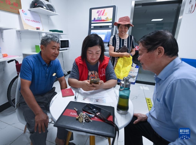 在浙江省杭州市臨安區(qū)玲瓏街道東山社區(qū)便民服務(wù)站，黨員志愿者幫助居民填寫公租房申請資料（2022年8月17日攝）。新華社記者 徐昱 攝