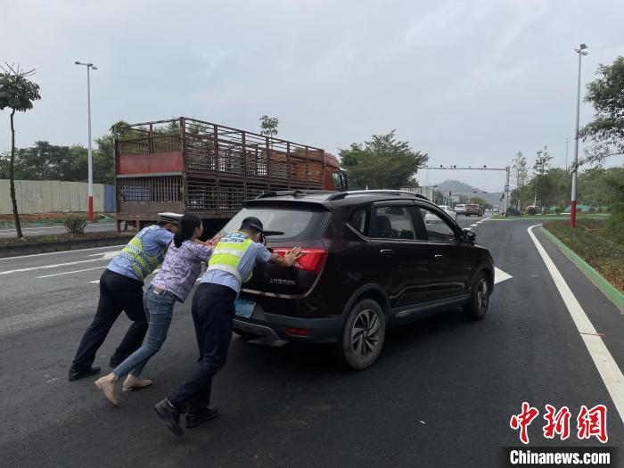 佛山高明公安警輔人員協(xié)助司機(jī)將故障車輛推至安全區(qū)域?！∥轲┤?攝