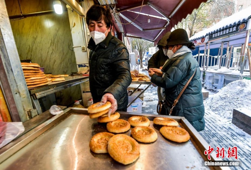 烏魯木齊市文化路，已開門營業(yè)的馕店吸引過往市民前來購買。 劉新 攝