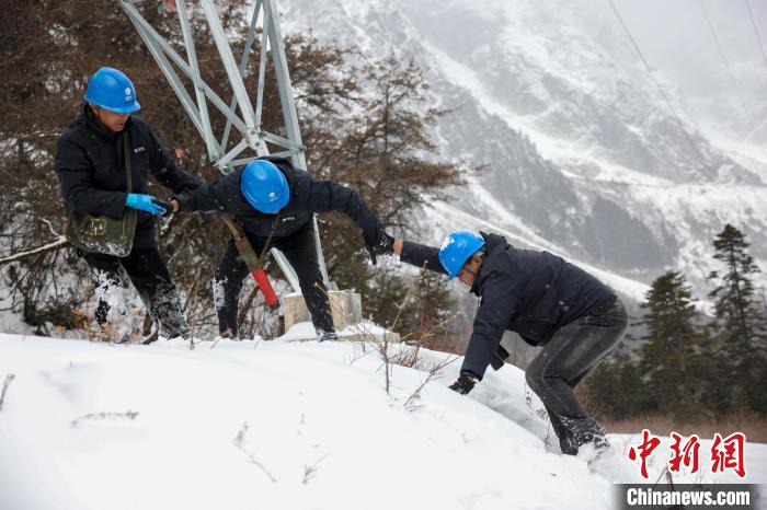 西藏波密縣電力巡護人員相互幫助，趟雪踏冰?！±顤|淮 攝