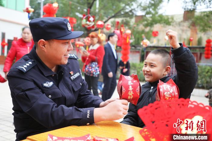 父子倆同時(shí)舉燈籠，臉上洋溢著幸福的笑容。　黃曉君 攝