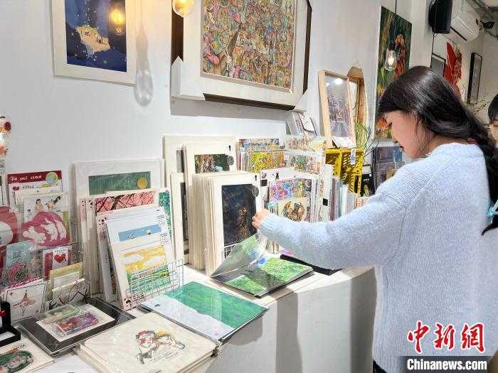 圖為藝術品商店內(nèi)，顧客挑選插畫作品。　鐘旖 攝