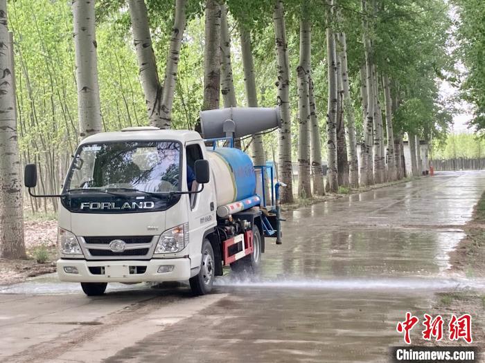 圖為灑水車在對地面進(jìn)行濕化，降低飄絮強(qiáng)度?！⌒戽?攝