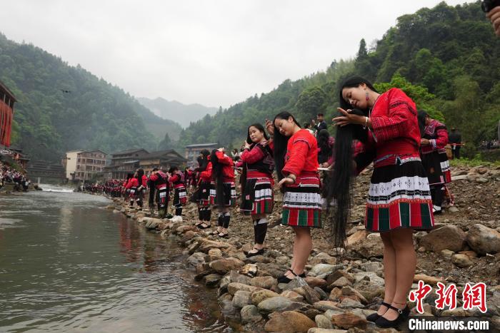 4月22日，在廣西龍勝各族自治縣龍脊鎮(zhèn)黃洛瑤寨，當(dāng)?shù)噩幾迕癖娫诤舆呴_展長(zhǎng)發(fā)梳妝表演?！№f吉陽(yáng) 攝