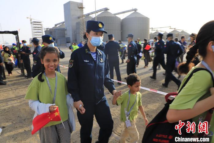 當(dāng)?shù)貢r(shí)間4月26日，海軍軍艦赴蘇丹緊急撤離我在蘇丹人員。圖為海軍官兵手牽著兒童通過安檢?！《〖遗d 攝