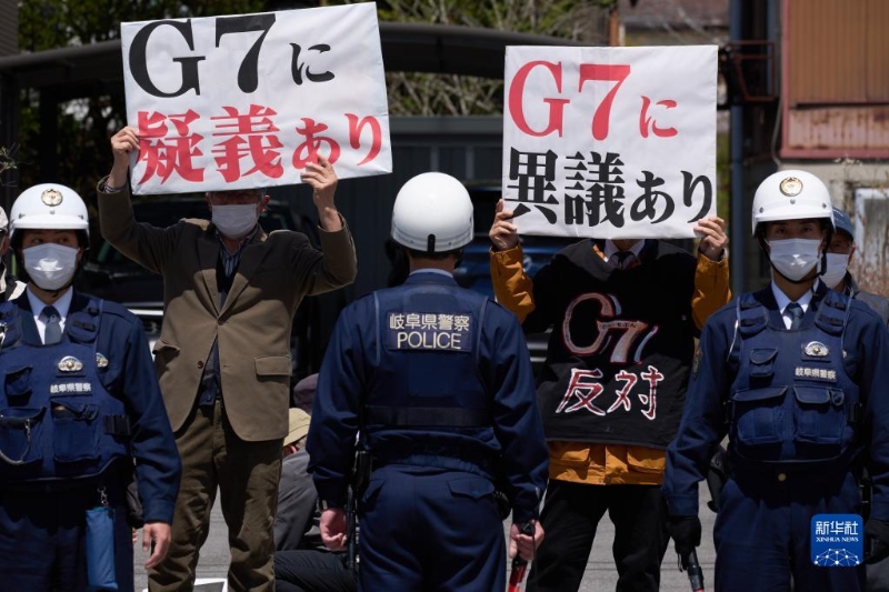 4月16日，在日本長野縣輕井澤車站附近，抗議者手舉標(biāo)語抗議。（圖源：新華社）