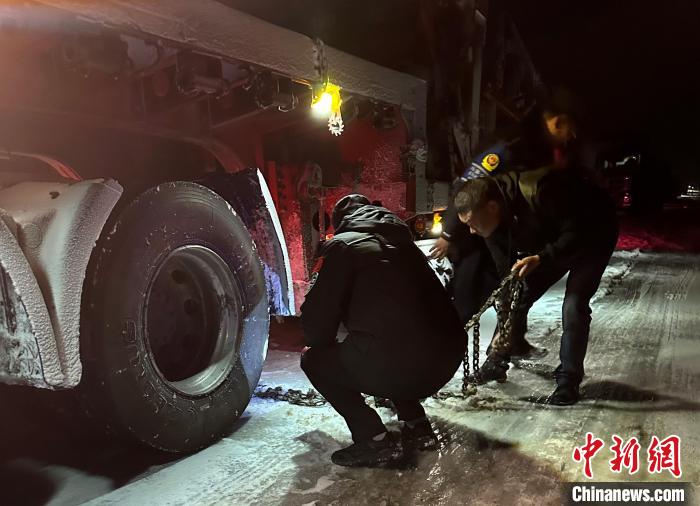 圖為民警幫助受困車輛安裝防滑鏈?！」逯菸麄鞑抗﹫D