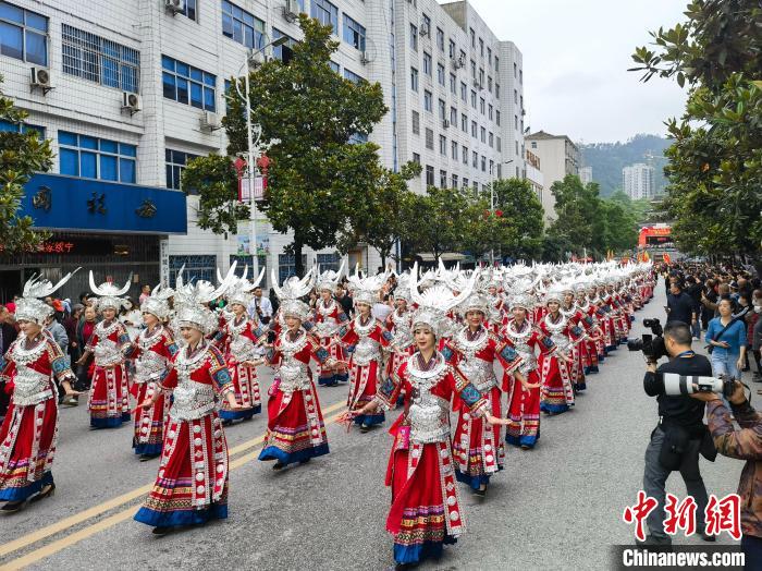 上百名美麗的姑娘著節(jié)日盛裝與蘆笙隊(duì)伍進(jìn)行巡游?！「毒窜?攝