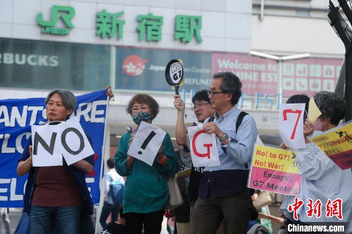 5月21日，日本民眾手舉標(biāo)語(yǔ)，在東京新宿車站附近舉行集會(huì)，強(qiáng)烈抗議G7廣島峰會(huì)。　蔣文月 攝