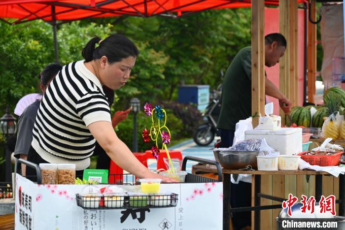 上金貝村村民擺攤售賣畬族美食?！∮嗌强?攝