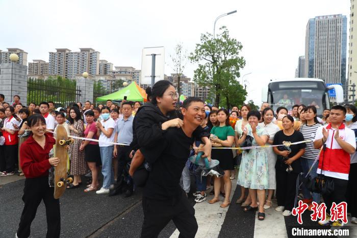 圖為蔣張子怡的父親背著她往外走，母親拿著女兒的滑板跟在后面?！⒄祭?攝