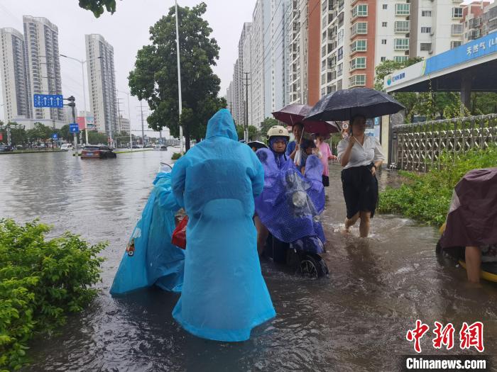 6月8日，強(qiáng)降雨過(guò)后，北海市民涉水出行?！〉岳顝?qiáng) 攝