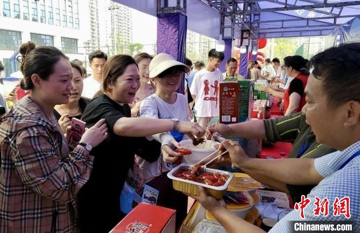 圖為江西南昌英雄城啤酒龍蝦燒烤節(jié)上，游客爭相品嘗鐵河小龍蝦預(yù)制菜?！⌒陆▍^(qū)融媒體中心供圖