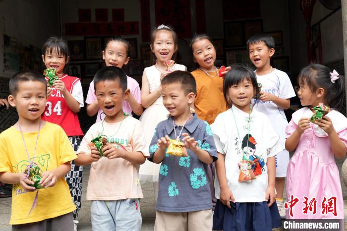 長(zhǎng)輩給孩子們戴上香包?！∮蓝ㄍ翗蔷皡^(qū)供圖