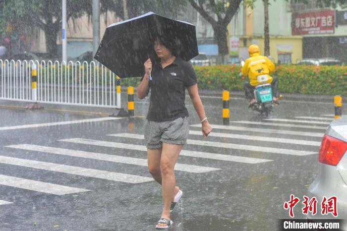 圖為海口市民冒雨出行。　駱云飛 攝