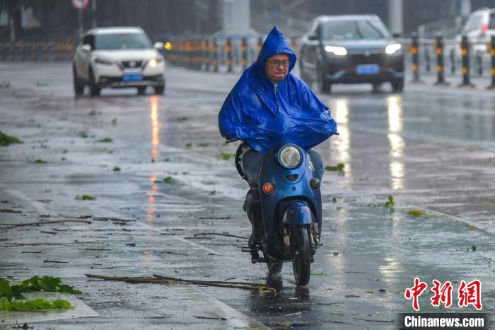 圖為海口市民冒雨出行。　駱云飛 攝