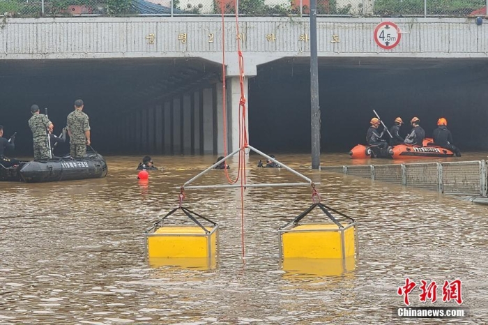 韓國(guó)救援人員沿著一條被洪水淹沒(méi)的道路搜尋失蹤人員，這條道路通往被洪水淹沒(méi)的地下隧道。視覺(jué)中國(guó)