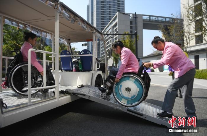 資料圖：10月16日，運(yùn)動員在亞殘運(yùn)村使用無障礙接駁車。<a target='_blank' href='/'>中新社</a>記者 王剛 攝