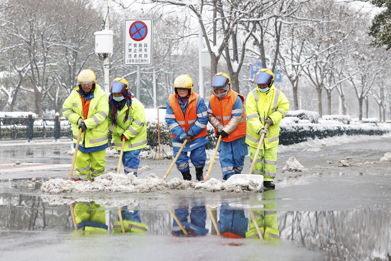 2月4日，在江蘇省宿遷市泗洪縣泗州大街，工作人員在清掃路面積雪。（圖源：新華社）