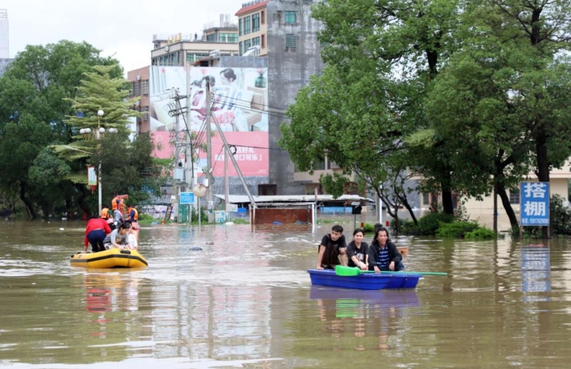 4月21日，廣東清遠(yuǎn)英德市浛洸鎮(zhèn)居民在積水的道路上乘船出行。新華社記者 黃國(guó)保 攝