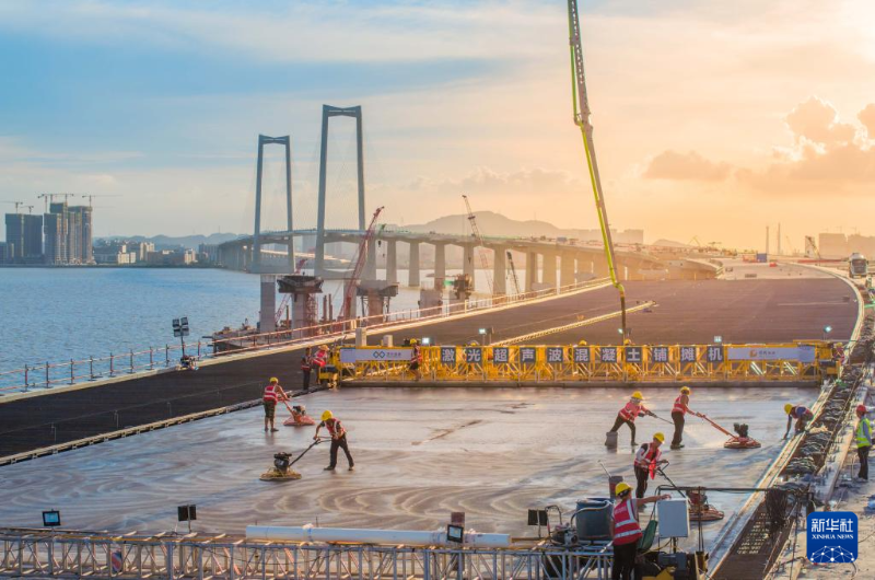 2023年6月27日，建設(shè)者在深中通道中山大橋鋪設(shè)橋面混凝土（無(wú)人機(jī)照片）。（圖源：新華社）